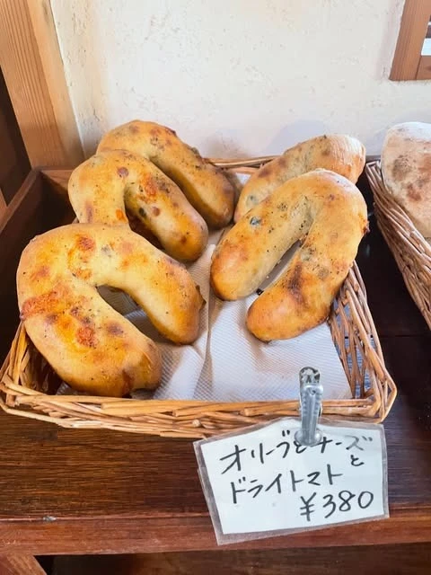 工房のかごに並んだ、オリーブとチーズ・ドライトマトのパン